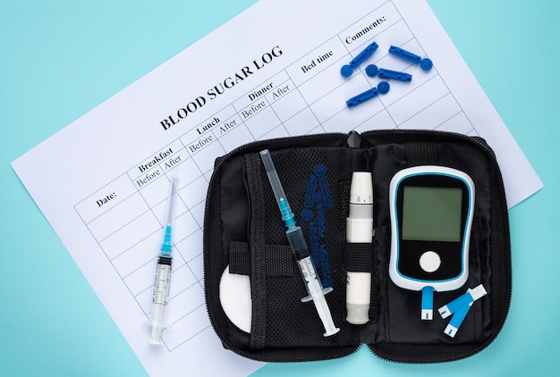 Dagelijks bloedglucoselogboek met suiker of insuline die meting controleert die op lichtblauwe hoogste mening wordt geplaatst als achtergrond