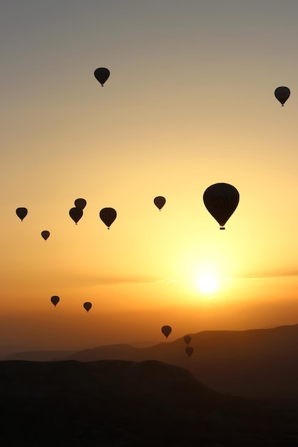 Dageraad in de bergen met ballonnen Turkije Cappadocië