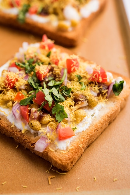 Dahi Bread papdi chaat、chatは、トマト、セブ、コリアンダー、マサラを添えたプレートで提供される、インドのおいしい前菜または前菜です。セレクティブフォーカス