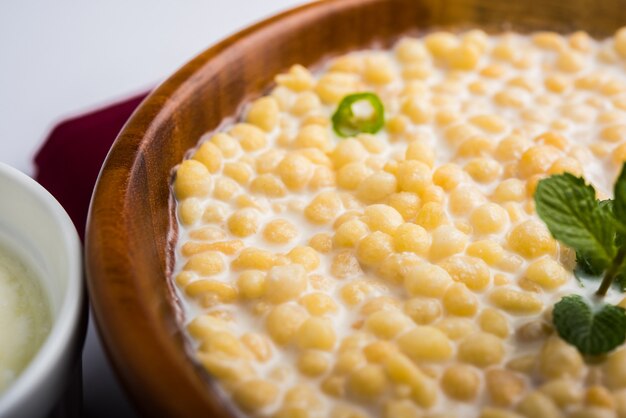 Dahi Bundi or Boondi Raita with curd, is a Popular side dish from Rajasthan, India. Served with coriander toppings in a bowl over colourful or wooden background. Selective focus