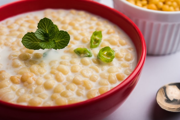 Dahi bundi o boondi raita con cagliata, è un contorno popolare del rajasthan, in india. servito con condimenti al coriandolo in una ciotola su sfondo colorato o in legno. messa a fuoco selettiva