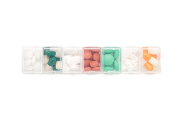 Daily pill box with medications and nutritional supplements isolated on white