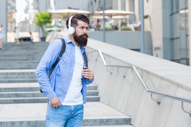 Daily route to work Modern life Change of scenery concept Handsome hipster with backpack walking street Walking through empty streets Man with headphones walking city center Listening music