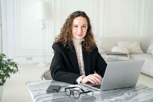 Daily work in the office a young freelance woman smiles in a business suit an office employee