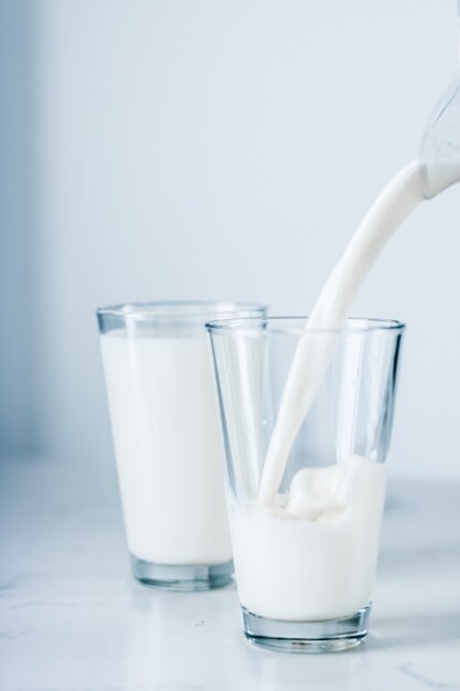 Dairy healthy nutrition and breakfast concept  world milk day pouring into glass on marble table