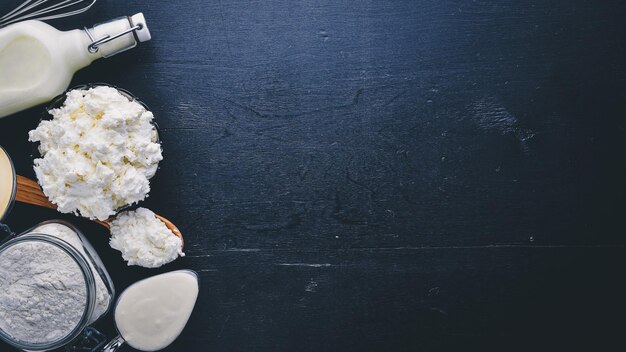 Dairy products Cheese cottage cheese milk sour cream on a black wooden background Top view Free space