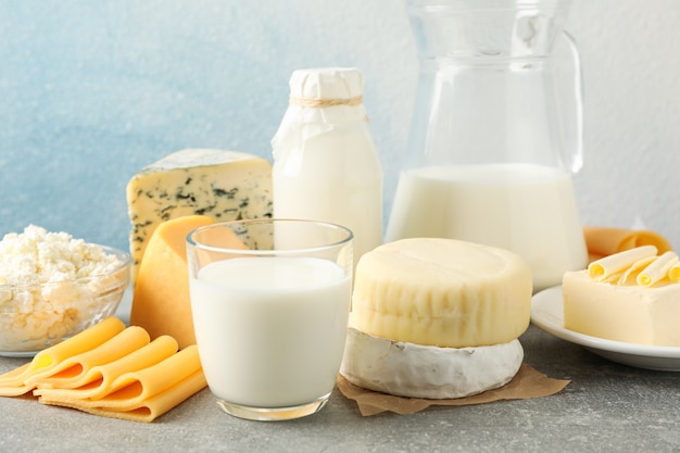 Dairy products on grey table against blue background