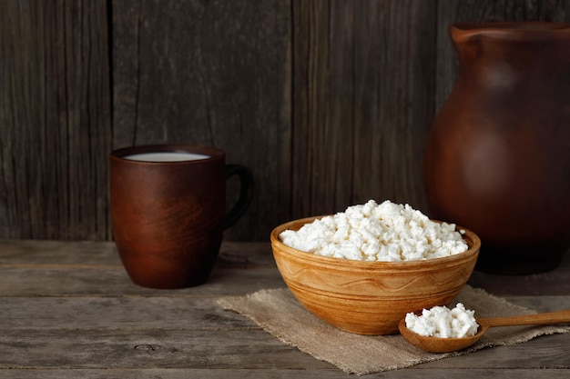 dairy products milk and cottage cheese in earthenware on rustic wooden table