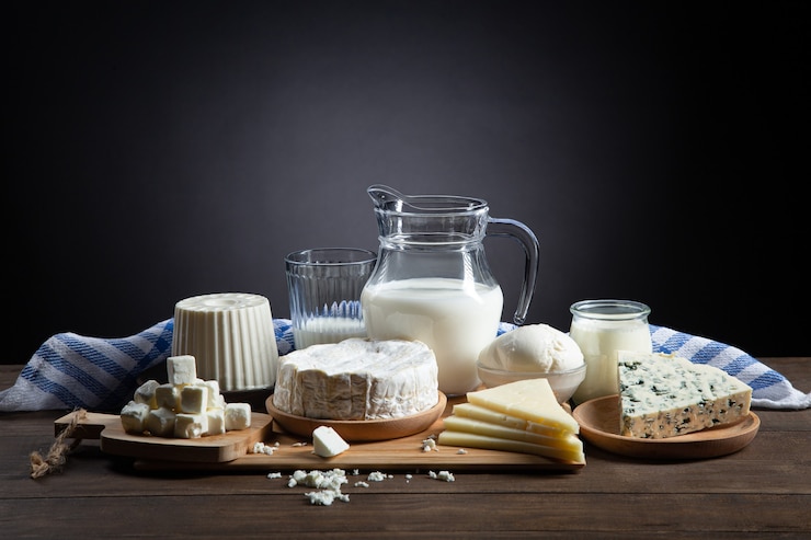 Фотография молочные продукты на деревянной основе и темном фоне с копией пространства.