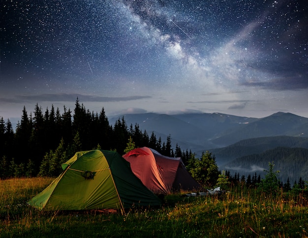 Dairy Star Trek above the tents. Dramatic and picturesque scene at night mountains.