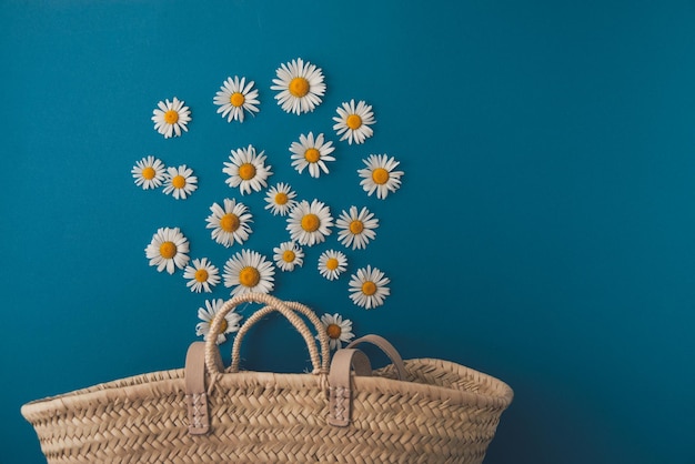 Daisies fall into a straw bag