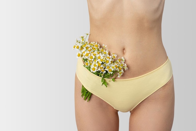 Daisies in women's hands and underwear The concept of female intimate hygiene and health naturalness