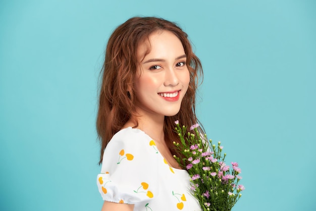 Daisy flowers field holds a young woman in blue