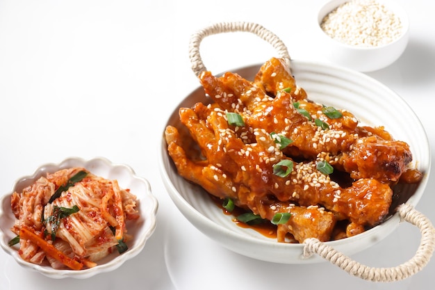 Dakbal or Maeun Dakbal is Spicy Chicken Feet, Korean Food Style served with sesame seeds and Kimchi.