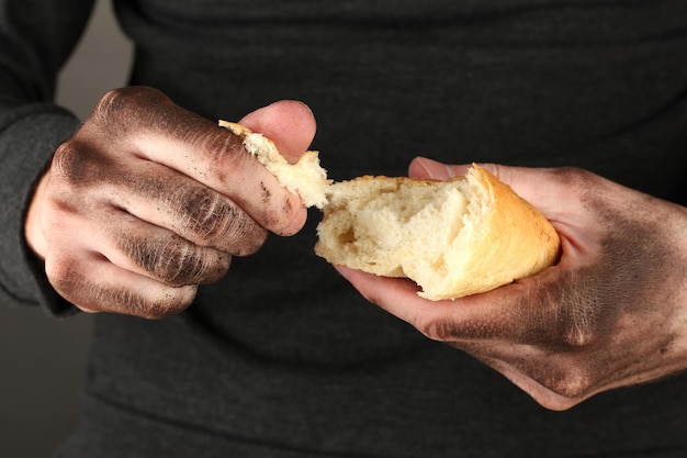 Dakloze man met een wit brood close-up