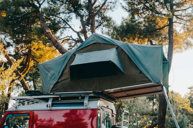 Daktent voor kamperen op het imperiaal van en off-road SUV-auto in een natuurpark