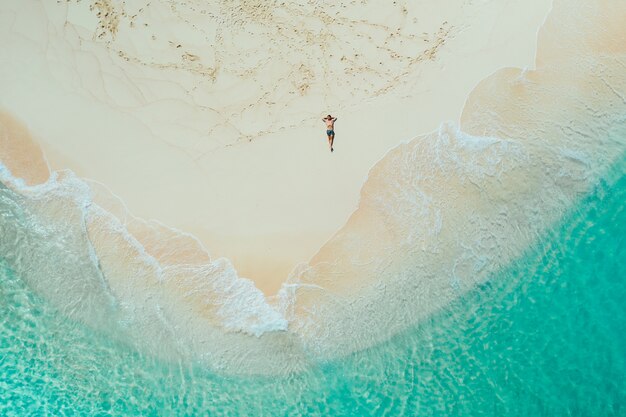 Daku island view from the sky. Man relaxing taking sunbath on the beach.shot taken with drone above the beautiful scene. concept about travel, nature, and marine landscapes