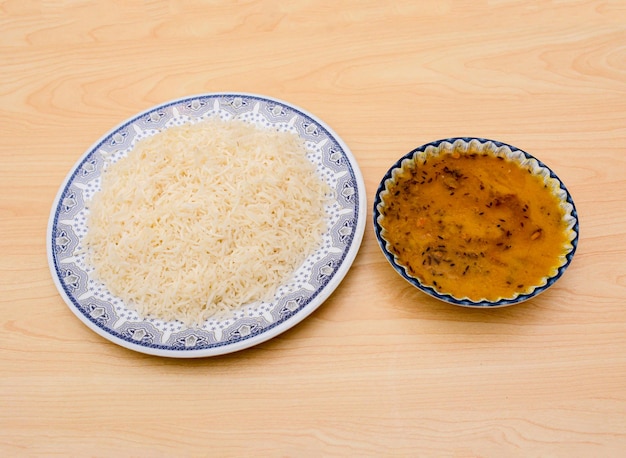 Dal chawal 또는 흰색 쌀은 탁자 위에 놓인 인도 매운 음식에 분리된 접시에 제공됩니다.