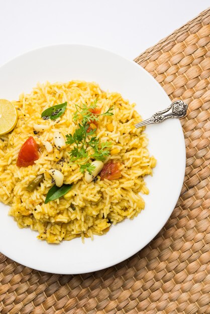 Dal khichadi or Khichdi Tasty Indian recipe served in bowl over moody background is made of toovar dal and rice combined with whole spices, onions, garlic and tomatoes etc. Selective focus