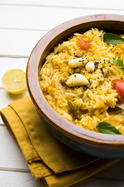 Dal khichadi of Khichdi Lekker Indiaas recept geserveerd in een kom op een humeurige achtergrond is gemaakt van toovar dal en rijst gecombineerd met hele kruiden, uien, knoflook en tomaten enz. Selectieve focus