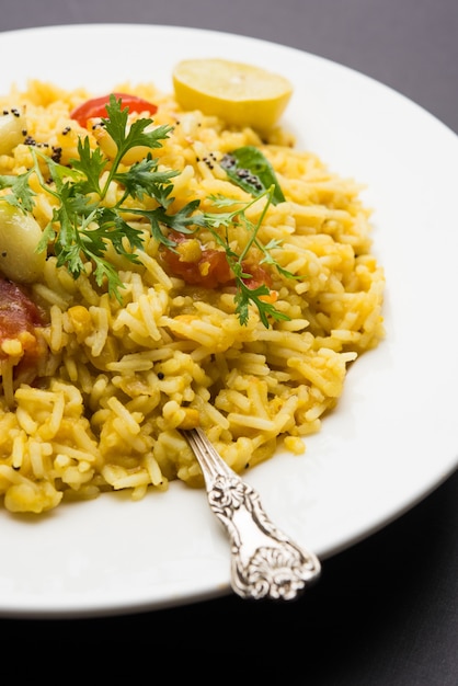 Dal khichadi of Khichdi Lekker Indiaas recept geserveerd in een kom op een humeurige achtergrond is gemaakt van toovar dal en rijst gecombineerd met hele kruiden, uien, knoflook en tomaten enz. Selectieve focus