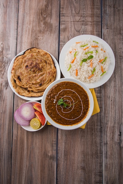 Dal makhani o daal makhni, pranzo o cena indiano servito con riso semplice e burro roti o chapati o paratha e insalata