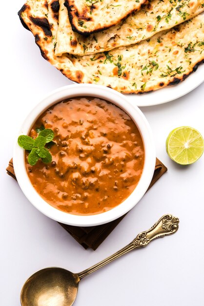 Dal makhani or daal makhni is a popular food from Punjab, India made using  whole black lentil, red kidney beans, butter and cream and served with garlic naan or Indian bread or roti