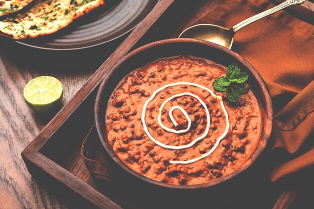 Dal makhani o daal makhni è un alimento popolare del punjab, in india, realizzato con lenticchie nere intere, fagioli rossi, burro e panna e servito con naan all'aglio o pane indiano o roti