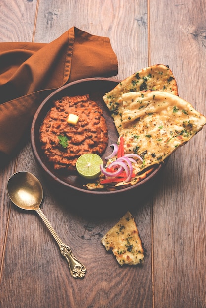 Dal makhani or daal makhni is a popular food from Punjab, India made using  whole black lentil, red kidney beans, butter and cream and served with garlic naan or Indian bread or roti