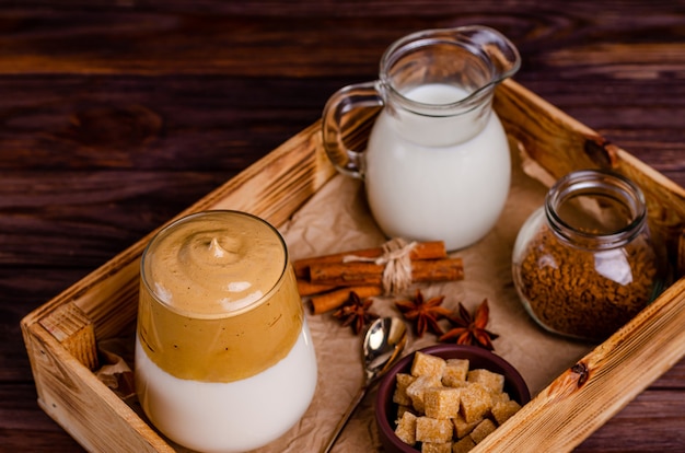 Dalgon-koffie met ingrediënten voor de bereiding in een doos op een houten achtergrond. Kopieer ruimte, plat leggen, ruimte voor tekst. Detailopname.