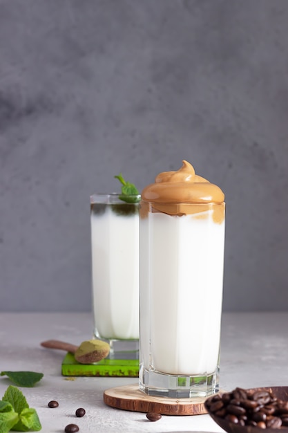 Фото Кофе dalgona и латте с маслом мяты и мяты, пушистый сливочный кофе со взбитыми сливками и бамбуковой соломкой
