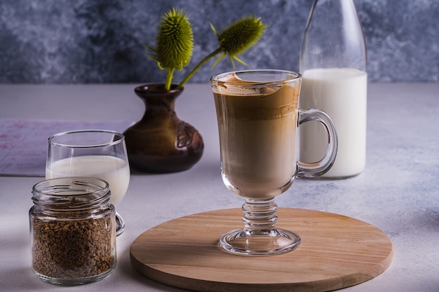 Dalgona espresso latte e ingredienti per la sua preparazione su un tavolo grigio. messa a fuoco selettiva.