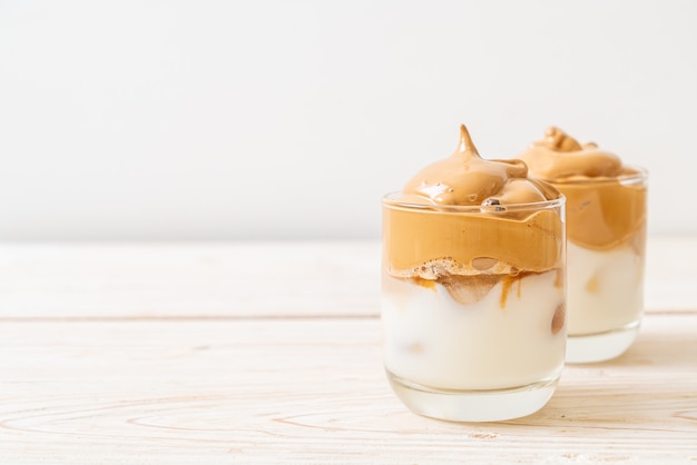 Dalgona koffie. Iced fluffy creamy whipped trend drink met koffieschuim en melk.