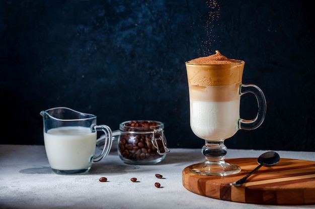 Dalgona koffie met zeven cacao op donkere muur. Trendy romige slagroomkoffie. Zuid-Koreaanse koude zomerdrank