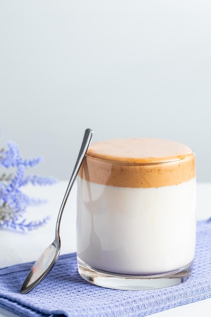 Dalgona-koffie op een lichte ondergrond Modieuze trendy drank gemaakt van melk en zoet slagroom