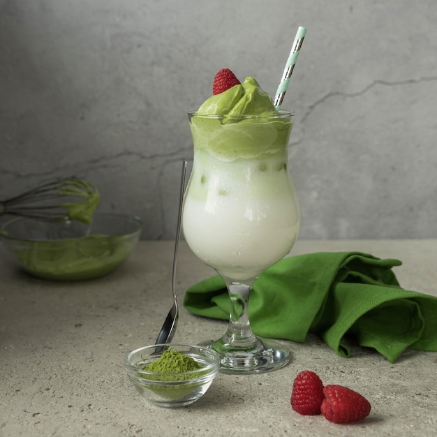 Dalgona matcha  and raspberries  on a grey  background with a copy space   Trendy drink