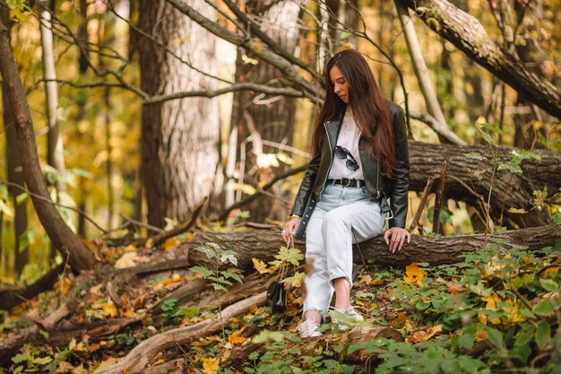 Dalingsconcept - mooie vrouw in de herfstpark onder dalingsgebladerte