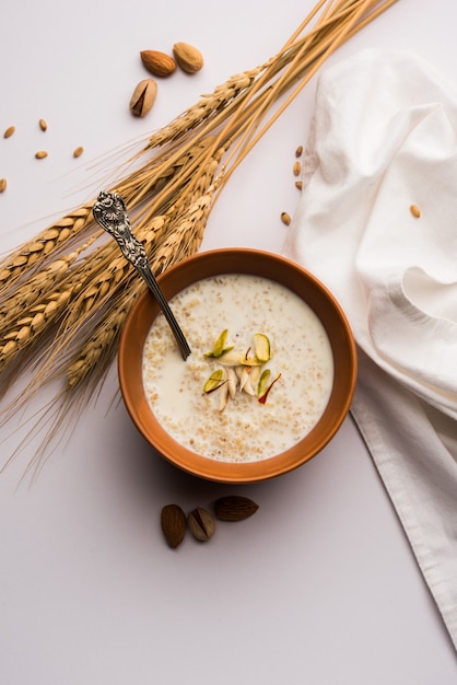 Photo daliya kheer or dalia payasam ãâ¢ãâãâ broken or cracked wheat and milk porridge with sugar cooked in indian way. dalia is a popular breakfast cereal in north india