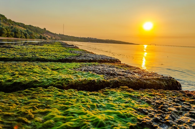 A dam made of stone slabs in the sea at sunrise.