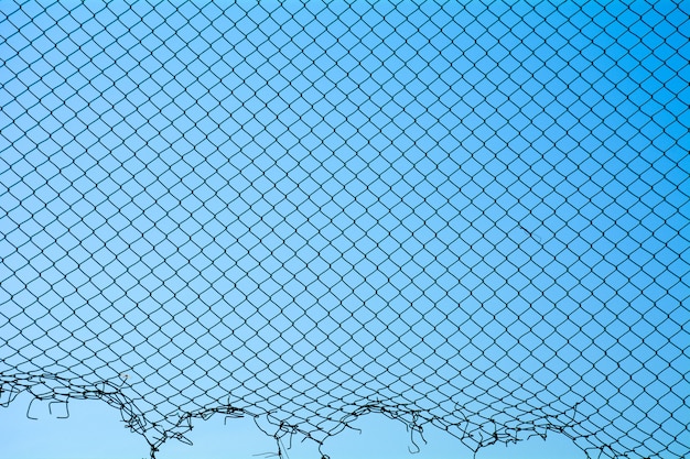 Photo damage wire mesh steel on blue sky background