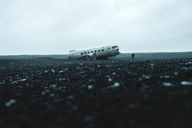 damaged airplane on sand against sky
