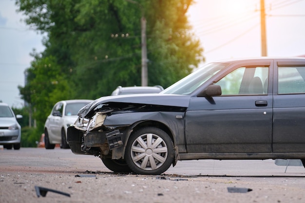 Damaged in car accident vehicle on city street crash site.