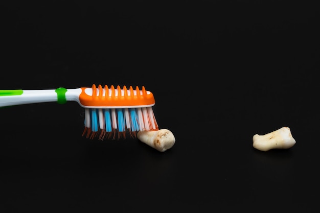 Damaged caries teeth with toothbrush on black background