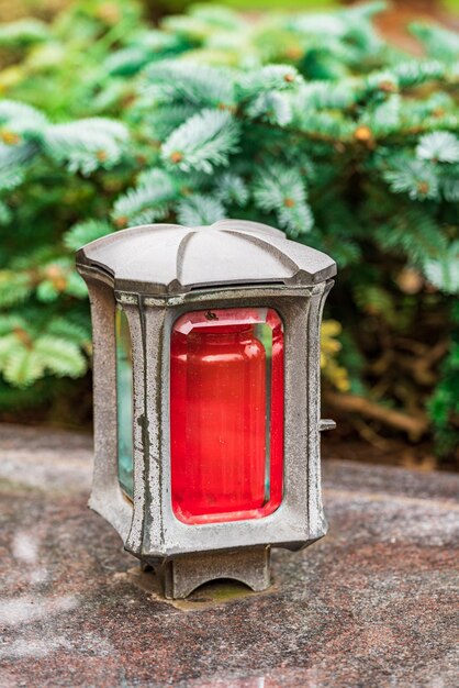 Damaged grave light with candle on a grave