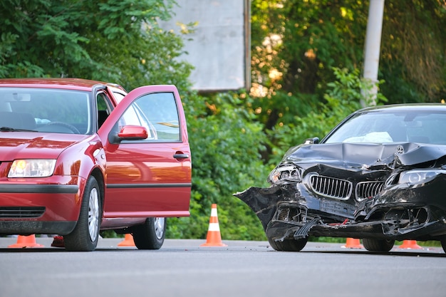 Damaged in heavy car accident vehicles after collision on city street crash site. Road safety and insurance concept.