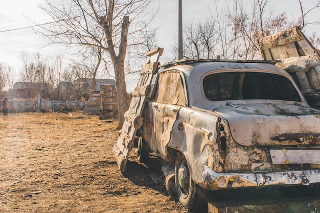 Damaged old car on the paintball arena