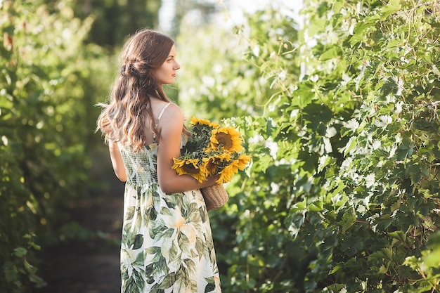 Dame buitenshuis. Vrouw met zonnebloemen.