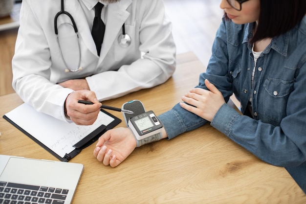 Dame die een tonometer van het polstype draagt tijdens de controle in de kliniek