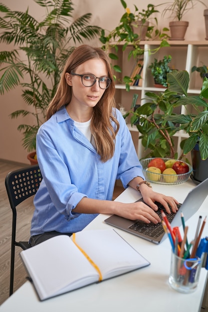 Dame met een bril die laptop gebruikt tijdens het studeren