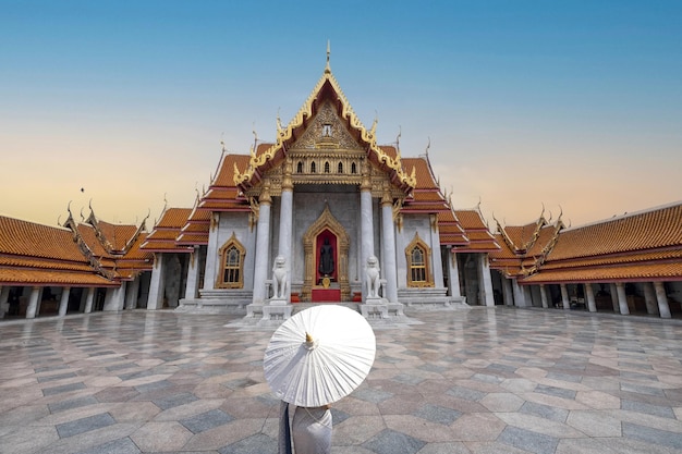 Dame met een paraplu die zich tegen de Marmeren tempel Bangkok Thailand bevindt